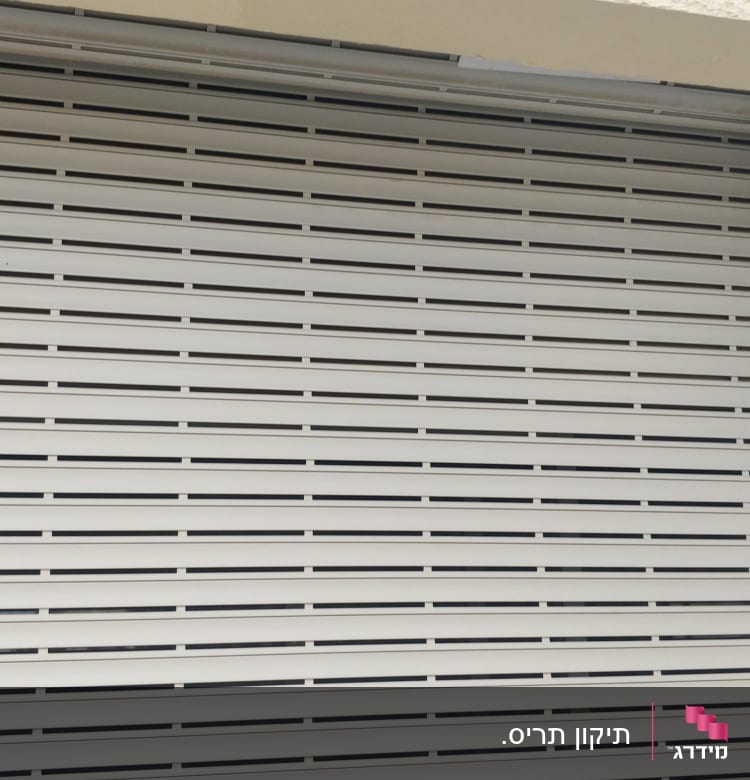 תריסים לבנים סגורים עם חריצים אופקיים